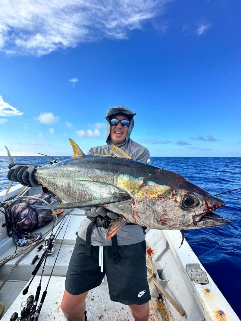 Angler holding a large yellowfin tuna on deck