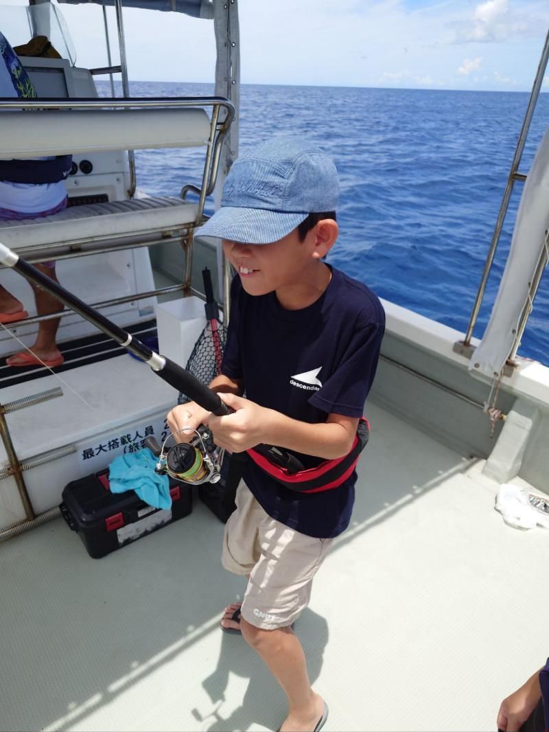 Young angler reeling in on a charter boat